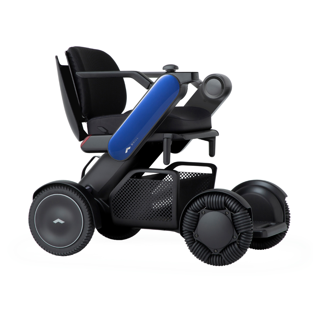 The Whill Model C2 Smart Power Chair is a compact, portable mobility device in black and blue with large wheels, supportive seat, armrests, footrest, storage basket, sleek design, and FDA Class II medical device compliance.