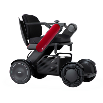 The Whill Model C2 Smart Power Chair - Compact Portable Mobility features a modern design with large wheels, black seat, red side panels, armrests, and a roomy under-seat basket; it's FDA-compliant as a Class II medical device.