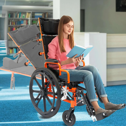 A young woman sits reading a book in a modern library, using the Circle Specialty ZIGGO Pro Reclining Pediatric Wheelchair, with blue carpet and bookshelves in the background.