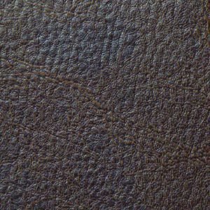 A close-up of dark brown leather texture with a rough, pebbled surface mirrors the luxury of the Golden Tech PR510 MaxiComfort Cloud Recliner With Lift Assist - Extra Wide. Natural patterns and creases give it an organic and rugged look.