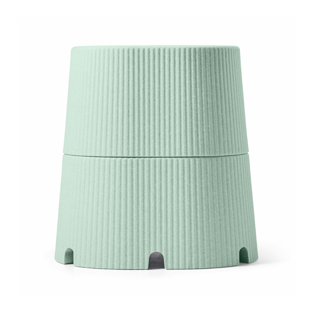 A light green, ribbed, cylindrical container with a tapered design and arch-shaped base openings, inspired by the byACRE DORICA Versatile Step Stool & Seat—water-resistant and anti-slip.