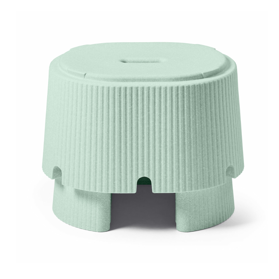 The byACRE DORICA Versatile Step Stool & Seat is a small, light green, cylindrical stool with a ribbed texture, flat top, and four wide curved legs. It's water-resistant and anti-slip for added safety.