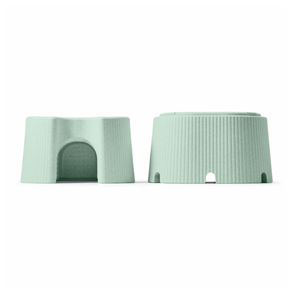 Two light green byACRE DORICA Versatile Step Stool & Seats, made of water-resistant, anti-slip plastic, feature small arched openings—one upright like a tiny house with a door, the other upside down to show its flat, ridged base on a white background.