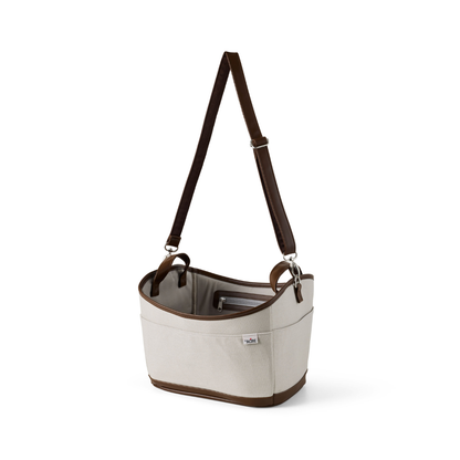 The byACRE Scandinavian Butler At-Home Rollator features a beige canvas design with brown leather trim, a wide adjustable strap, open-top style, and a side exterior pocket, inspired by Scandinavian Butler aesthetics.