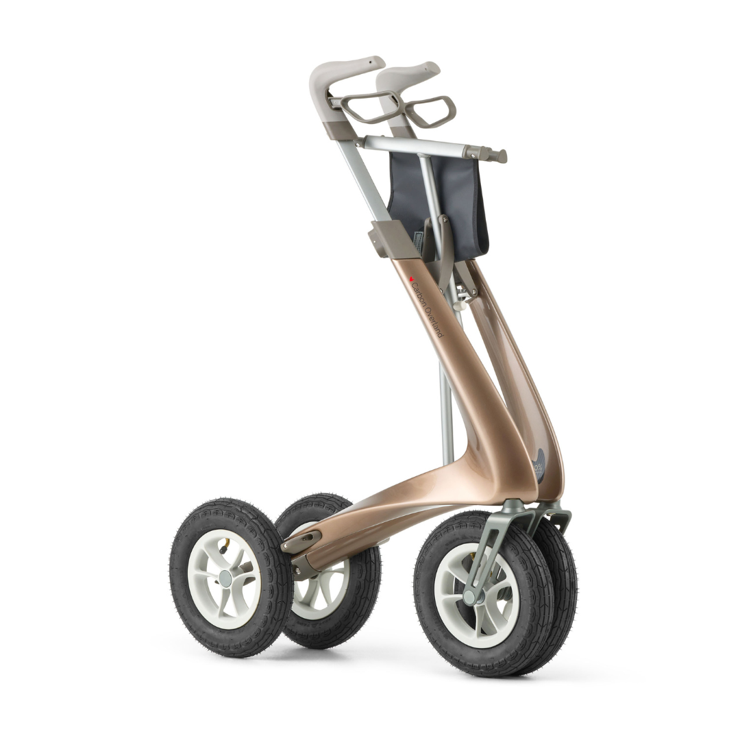 The ByACRE Carbon Overland All-Terrain Rollator features a bronze frame, large white-rimmed wheels, ergonomic handles, and a black front storage bag—your ideal companion for smooth and adventurous mobility on any terrain.
