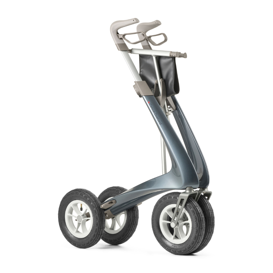 The ByACRE Carbon Overland All-Terrain Rollator pairs a sleek metallic frame, large rubber tires, ergonomic handles, and a black storage pouch—perfect for comfort and confidence on any daily adventure.