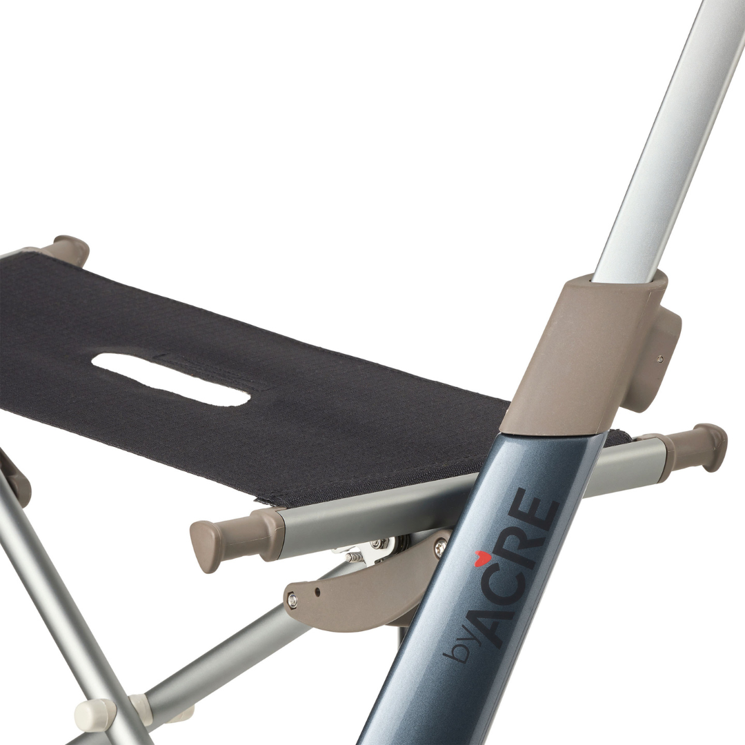 Close-up of the ByACRE Carbon Overland All-Terrain Rollator, featuring a black fabric seat with handle cut-out and metallic frame. Ideal for travel, the byACRE branding is visible on the frame.