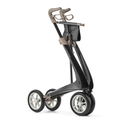 The ByACRE Ultralight Carbon Fiber Rollator (10.6 lbs) features a sleek black frame, four large white wheels, beige handle, compact design, and a storage pouch below the handle—lightweight and easy to maneuver like a modern golf push cart.
