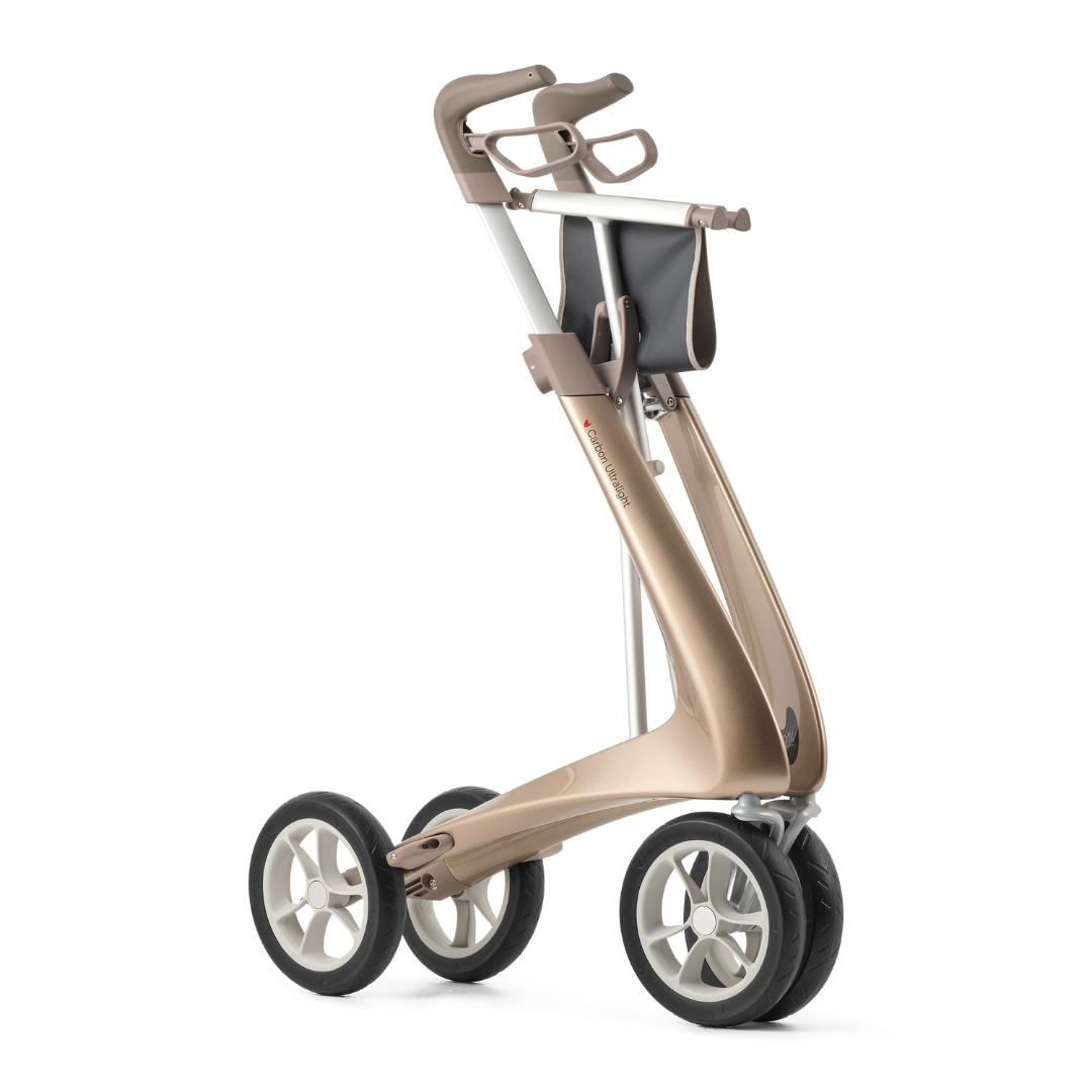 The ByACRE Ultralight Carbon Fiber Rollator (10.6 lbs) features four wheels, a sleek metallic gold frame, ergonomic handles, and a compact black storage bag beneath the handles.