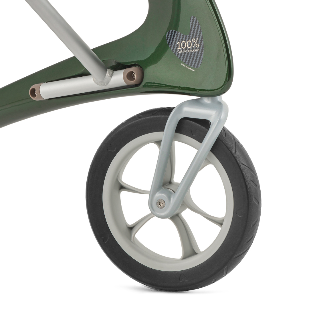 Close-up of a black rubber wheel with light gray rim on the green ByACRE Ultralight Carbon Fiber Rollator (10.6 lbs), featuring a 100% label with carbon fiber pattern above the wheel.
