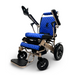 Introducing the ComfyGo MAJESTIC IQ-8000 Remote Controlled Lightweight Electric Wheelchair, featuring a blue and black color scheme with comfortable padded seating and foldable armrests. This travel-friendly model includes large rear wheels and smaller front wheels for optimal maneuverability. Its modern, sleek design is adorned with a Majestic label on the frame and comes equipped with convenient footrests.