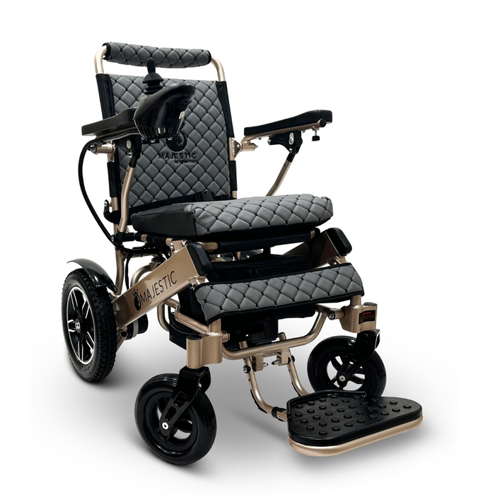 The ComfyGo MAJESTIC IQ-8000 is a stylish and portable electric wheelchair featuring a quilted black seat and backrest, a bronze frame, and black wheels. It comes with adjustable armrests and footrest, along with a joystick for control on the right armrest.