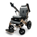 Introducing the ComfyGo MAJESTIC IQ-8000, a sleek and modern electric wheelchair designed in a lightweight, travel-friendly black and silver style. It comes with quilted cushions, adjustable armrests, a foldable footrest, and a user-friendly joystick control panel. The name "Majestic" is prominently displayed on the front.