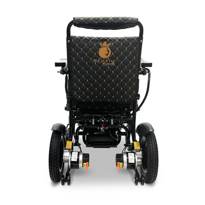 Introducing the ComfyGo MAJESTIC IQ-8000, a remote-controlled lightweight electric wheelchair exuding luxury. Featuring quilted fabric and gold accents, its backrest displays an embroidered lion alongside the word "Majestic" in gold. Its travel-friendly compact design, combined with large rear wheels, ensures elegance and ease while on the move.