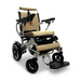 The ComfyGo MAJESTIC IQ-8000 is a stylish, travel-friendly electric wheelchair that features a quilted tan seat and backrest, black armrests, joystick controller, footrest, lightweight metallic frame with large rear wheels and smaller front wheels.