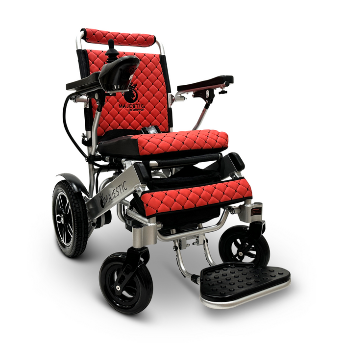 Introducing the ComfyGo MAJESTIC IQ-8000, a travel-friendly electric wheelchair in red and black with quilted upholstery. It features joystick control on the armrest, has a lightweight silver frame with four wheels, and is equipped with footplates at the front for added convenience.