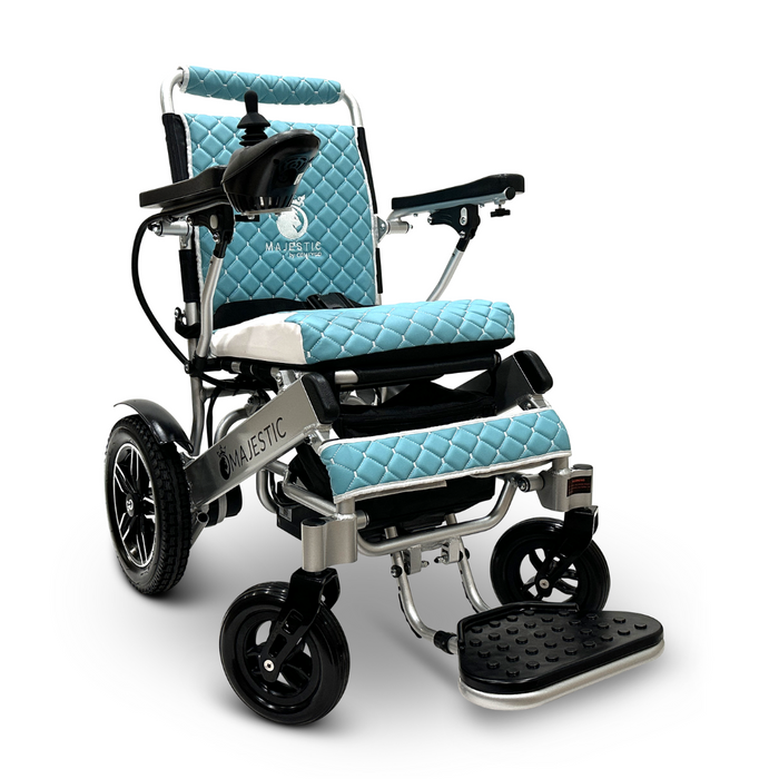 The ComfyGo MAJESTIC IQ-8000 Remote Controlled Lightweight Electric Wheelchair boasts a blue quilted design with black armrests and a footrest. Its lightweight build features joystick control on one armrest and four wheels, providing travel-friendliness along with exceptional mobility and comfort.