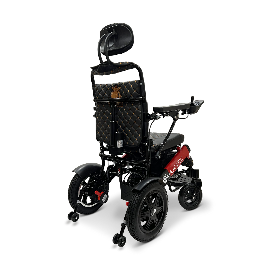 The ComfyGo MAJESTIC IQ-9000 Auto Recline Remote Controlled Electric Wheelchair is a black and red foldable electric model, featuring brushless silent motors. It includes a padded headrest, quilted backrest cover, and small rear wheels for a compact, portable design. Effortless control is provided by the digital joystick controller.