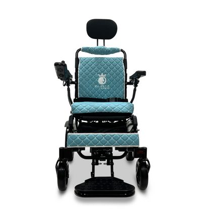Introducing the ComfyGo MAJESTIC IQ-9000 Auto Recline Remote Controlled Electric Wheelchair in a vibrant blue color, complete with a luxurious quilted seat and backrest. It features brushless silent motors for a smooth ride and includes a digital joystick controller conveniently located on the right armrest. The elegant word 'Majestic,' accompanied by a crown logo, is finely embroidered on the backrest.