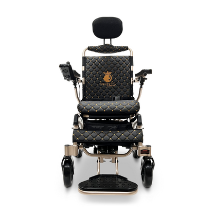 Front view of the elegant ComfyGo MAJESTIC IQ-9000 Auto Recline Remote Controlled Electric Wheelchair in black and gold, showcasing a quilted pattern with a headrest. It includes whisper-quiet brushless motors, a digital joystick controller on the armrest, and a footrest at the base for exceptional comfort and control.