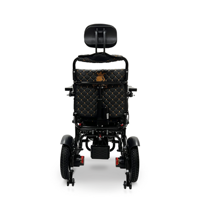 A black ComfyGo MAJESTIC IQ-9000 Auto Recline Remote Controlled Electric Wheelchair is shown from the rear, showcasing a quilted brown and gold patterned backrest and headrest. It is equipped with brushless silent motors, large rear wheels, smaller front wheels, and features a digital joystick controller on the right armrest.