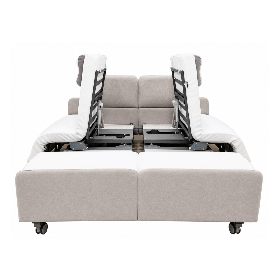 The Elevra Deluxe Rotating Lift Assist Bed - Dual King features a modern beige and white design with adjustable backrests and footrests, visible frame and reclining mechanisms inspired by homecare beds, and smooth wheels for easy movement.