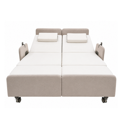 The Elevra Deluxe Rotating Lift Assist Bed - Dual King features two adjustable beds side by side with beige frames, white mattresses, matching rectangular pillows, head elevation, and wheels for mobility—perfect for advanced homecare.