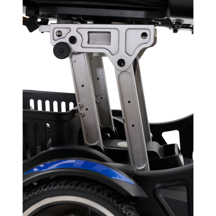 Close-up of the ultra-compact Golden Tech GP130 Buzzaround CarryOn Portable Powerchairs mechanical structure, highlighting metal joints and supports. A small basket is visible, while part of its folding wheel with a decorative blue stripe appears in the foreground.