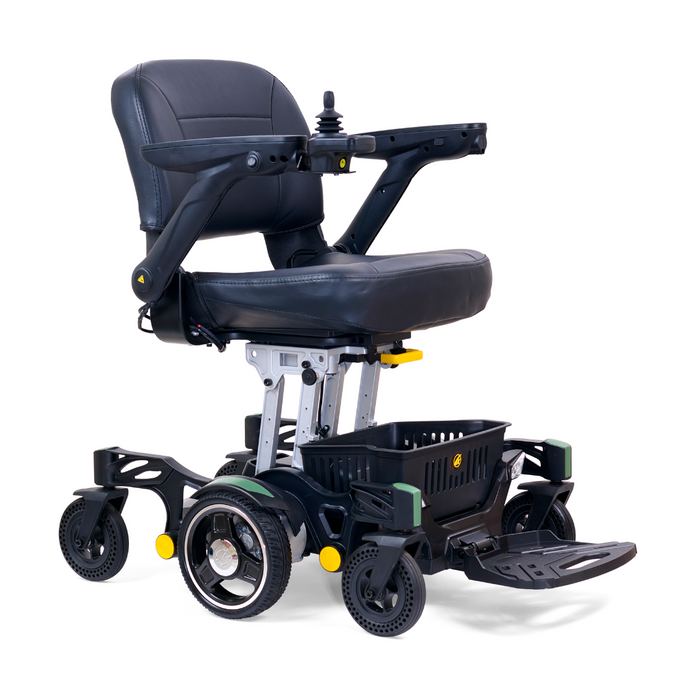 The Golden Tech GP130 Buzzaround CarryOn is a modern, ultra-compact black electric wheelchair with a cushioned seat and backrest, armrests, joystick control, footrest, four wheels (larger rear ones), and a basket beneath the seat.