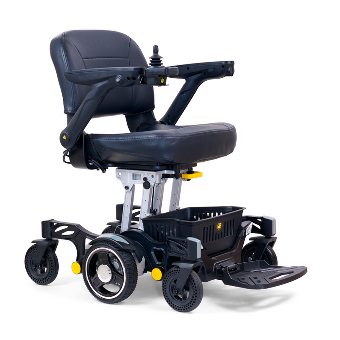 The Golden Tech GP130 Buzzaround CarryOn is a black folding power wheelchair with armrests, joystick control, and a cushioned seat. It features small front and rear wheels, fold-up footrests, and has grey and yellow accents adding to its ultra-compact sleek design.
