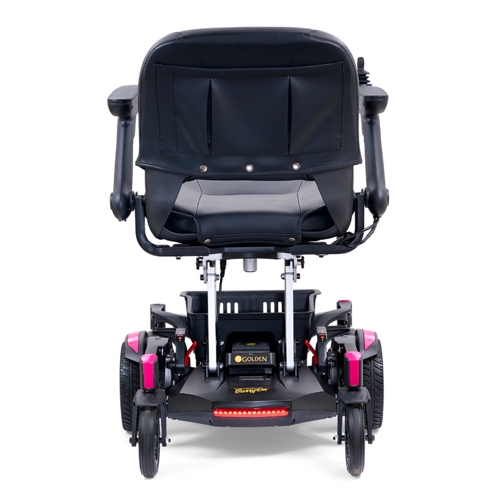 Rear view of the Golden Tech GP130 Buzzaround CarryOn, an ultra-compact folding power wheelchair with pink accents, featuring armrests, a cushioned seat, and four wheels for stability.