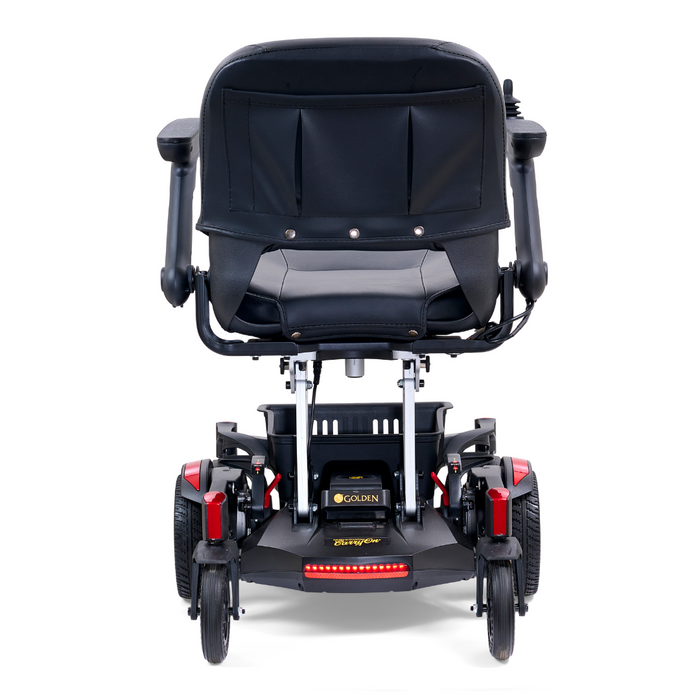The Golden Tech GP130 Buzzaround CarryOn Portable Powerchair features a rear view with a black and red design, sturdy wheels with 4-wheel suspension, armrests, and a wide seat with backrest. Its ultra-compact form includes a small rear platform for convenient use.