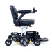 Meet the Golden Tech GP130 Buzzaround CarryOn Portable Powerchair: a compact chair with a black seat, adjustable armrests, right-arm joystick control, sturdy wheels, 4-wheel suspension, and a footrest for enhanced mobility and comfort.