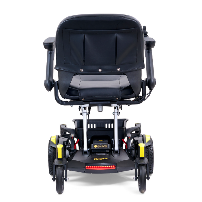 Rear view of the Golden Tech GP130 Buzzaround CarryOn Portable Powerchair with a black cushioned seat and armrests. The base, with four wheels, displays Golden at the back. Small red lights add to its sleek design, combining style and functionality.