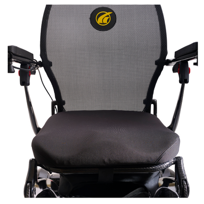 Close-up of the Golden Tech Carbon Fiber Cricket Power Wheelchair—just 33 lbs—with black mesh seat and backrest, armrests on both sides, and a yellow logo on the backrest.
