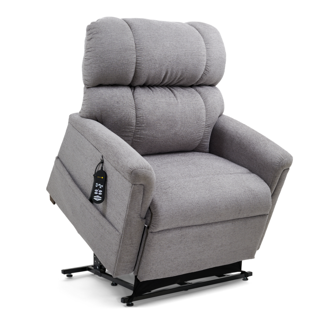 The Golden PR535 MaxiComfort Recliner w/ Lift Assist in medium has a plush backrest and armrests, displayed upright on a raised black base for ergonomic support. A remote with various buttons is attached to the left arm of this gray chair as part of the Comforter Series.