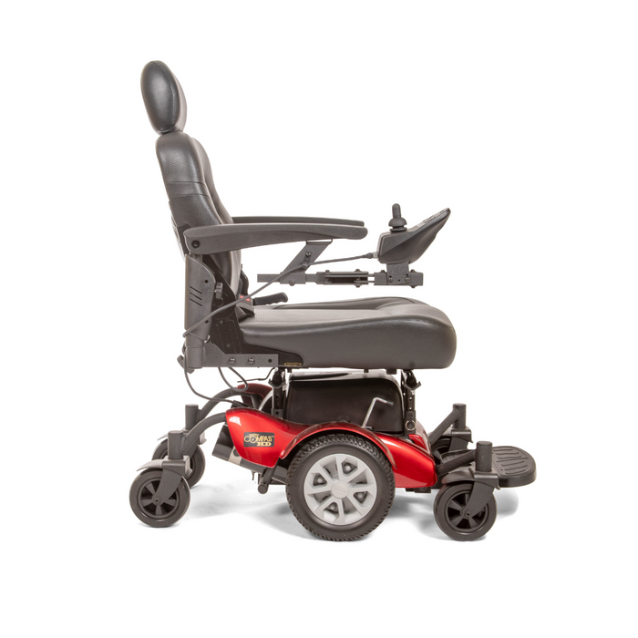 The Golden Tech GP620 Compass HD Bariatric Electric Wheelchair is a red and black heavy-duty power chair with a padded seat, headrest, and armrests. It features center-wheel drive for sleek maneuverability, joystick control on the right armrest, four sturdy wheels, and a robust metal footrest.