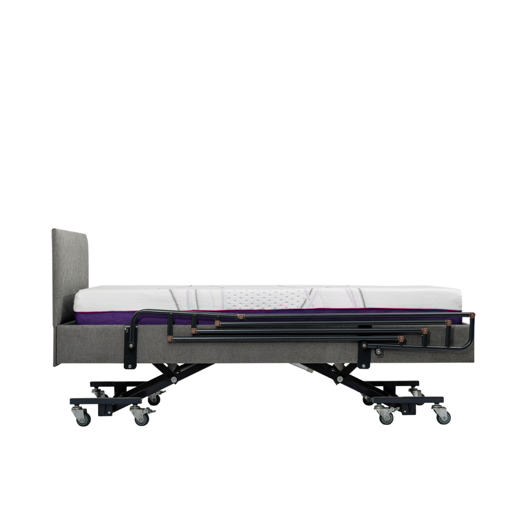 A gray adjustable hospital bed features iCare Medical Bed Safety Rails for support and fall prevention, with a headboard, caster wheels, and a white and purple mattress in flat position. The background is plain white.