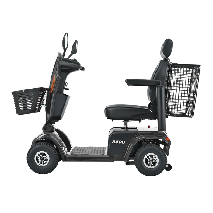 Side view of a black Metro Mobility S500 Heavy Duty 4-Wheel Power Scooter with a seat, armrests, large rear basket, and front basket; includes a control panel with mirrors.