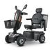 The Metro Mobility S500 Heavy Duty 4-Wheel Power Scooter features a black design with a comfy seat, armrests, backrest, and headrest. It includes front/rear wheels, a front basket, and rear wire carrier. The S500 model name and Metro logo are prominently displayed.