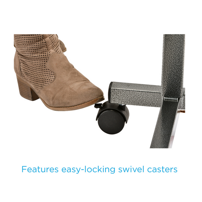 Someone in brown boots presses the lever on a swivel caster attached to a gray Nova Medical Rolling Overbed Table - Non Tilt. The table features easy-locking swivel casters and adjustable height.