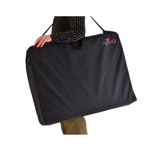 A person carries the Nova Extra-Large Carry & Travel Bag for Rollator Walkers & Transport Chairs, featuring a colorful “nova” logo on the top corner, using a shoulder strap. Only part of their body is visible.