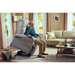 An elderly man smiles while enjoying the Journey Perfect Sleep Recliner & Lift Chair with Heat in a cozy living room featuring a beige sofa, coffee table, and large curtained windows.