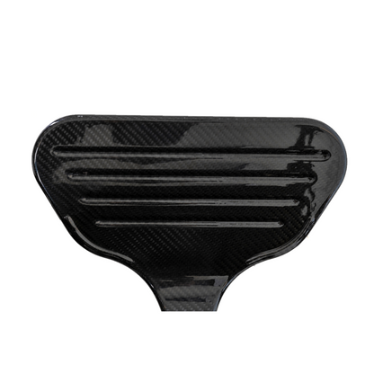 Close-up of a black Pride Mobility Jazzy® Carbon Ultralite Powerchair, highlighting its glossy carbon fiber finish with horizontal grooves. The ultra-lightweight texture is smooth and reflective, resembling a paddle or vehicle component.