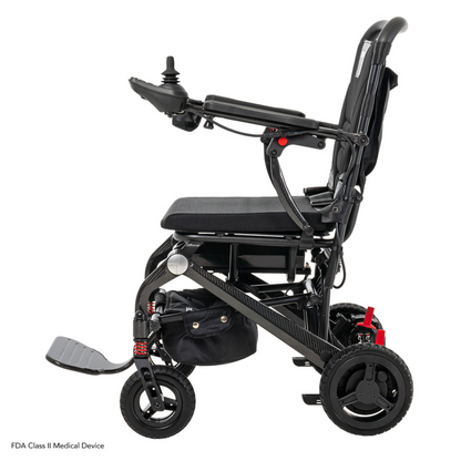 The Pride Mobility Jazzy® Carbon Ultralite Powerchair features joystick control, side view, ultra-light construction for easy travel, cushioned seating, foldable footrest, and sturdy wheels for smooth mobility. Its compact frame ensures effortless maneuverability.