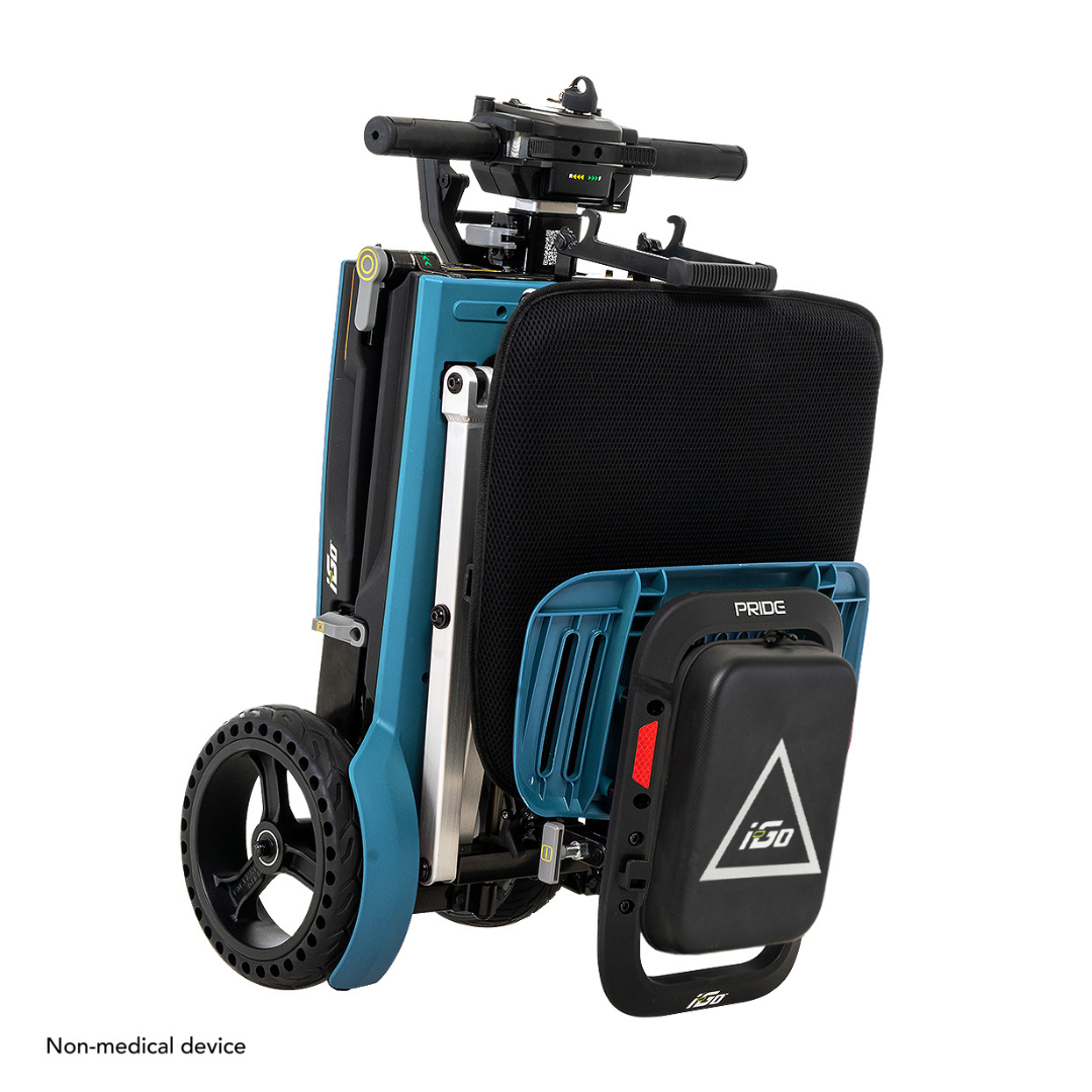 The Pride Mobility i-Go™ Portable Travel Scooter is a compact, foldable mobility solution with an ultra-compact profile, black seat, large back wheels, and top handlebars. A small triangular logo on the back declares it a Non-medical device.