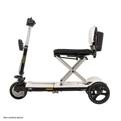 The Pride Mobility i-Go™ Portable Travel Scooter is ultra-compact and foldable with three wheels. Its sleek white frame, elevated black seat, upright handlebar, and larger rear wheels provide stability. Its a non-medical device featuring feather-touch disassembly.