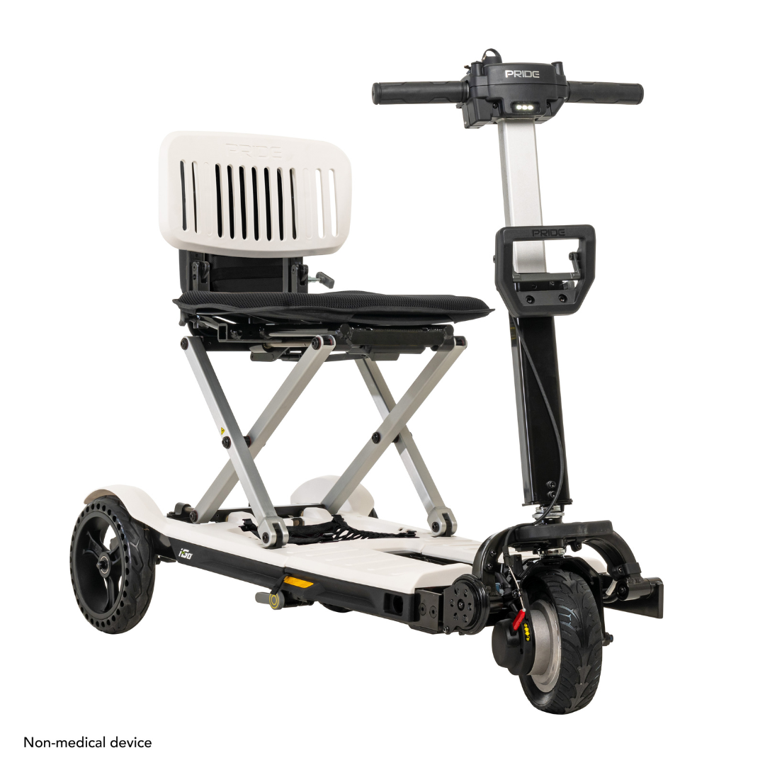 The Pride Mobility i-Go™ Portable Travel Scooter includes a foldable seat and backrest, two front wheels, one rear wheel, and a metal frame with an ultra-compact profile and control handlebar. The bottom left text states Non-medical device.
