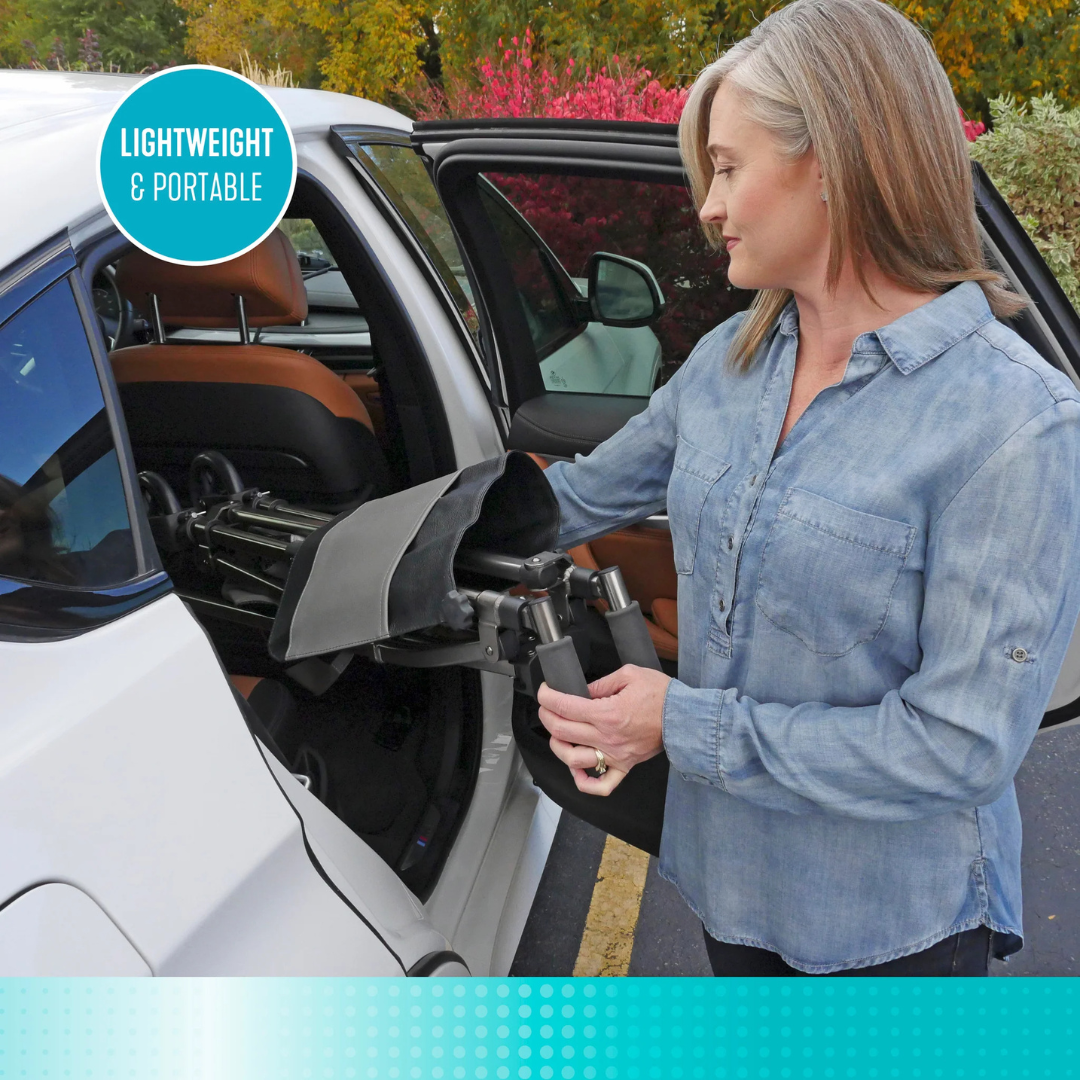 A woman in a denim shirt loads the Signature Life Elite Bariatric Travel Walker, labeled LIGHTWEIGHT & PORTABLE, into the back seat of a white car. Autumn trees and bushes are visible in the background.