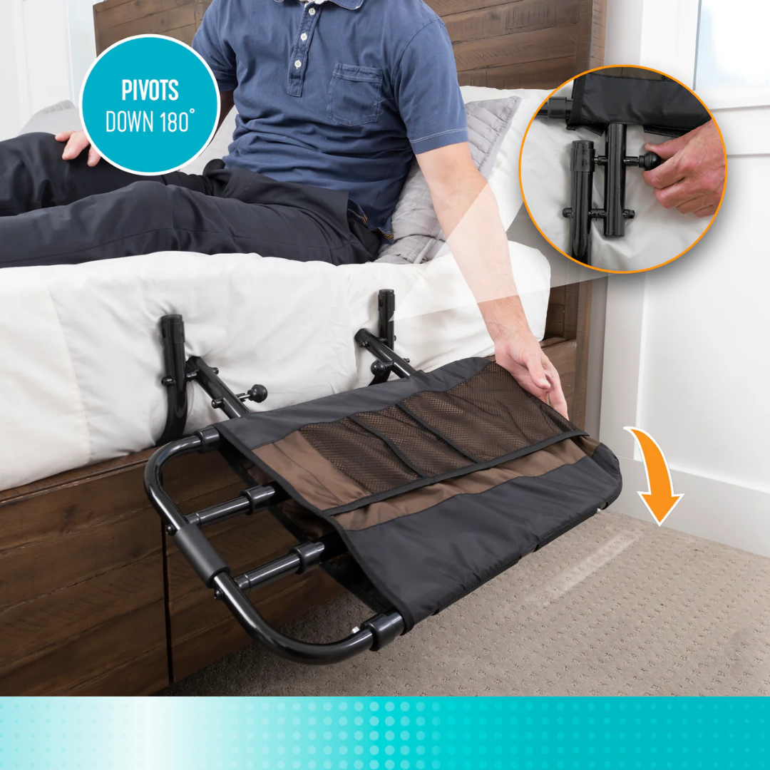 A person on a bed lowers the Stander EZ Adjust Bed Rail with a storage pouch, pivoting it 180° down for added fall protection. An inset shows a close-up of the rail’s folding mechanism.